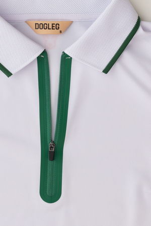 Polo de golf Dogleg Performance femme blanc et vert porté par une golfeuse — golf Suisse