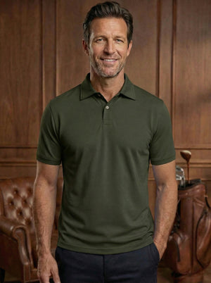 Polo de golf Dogleg Tailored vert foncé porté par un golfeur — coupe ajustée, golf Suisse